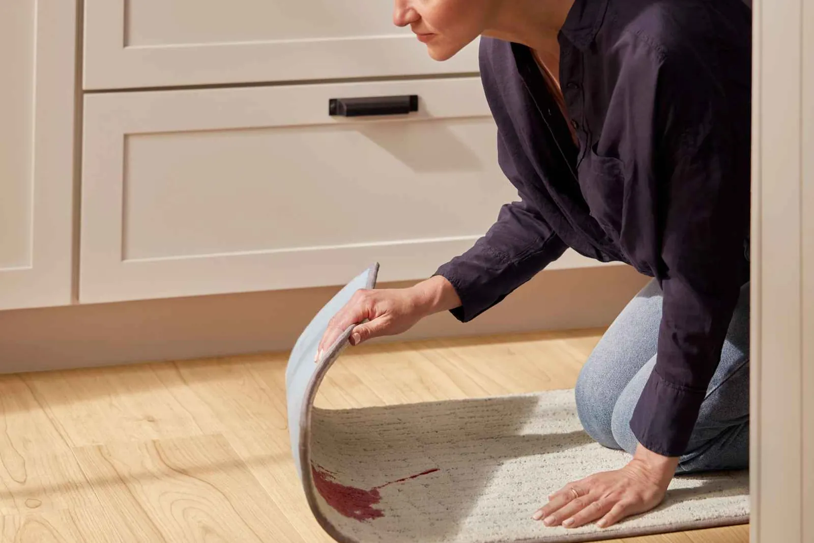 Lifting a washable rug with a stain, waterproof luxury vinyl plank underneath