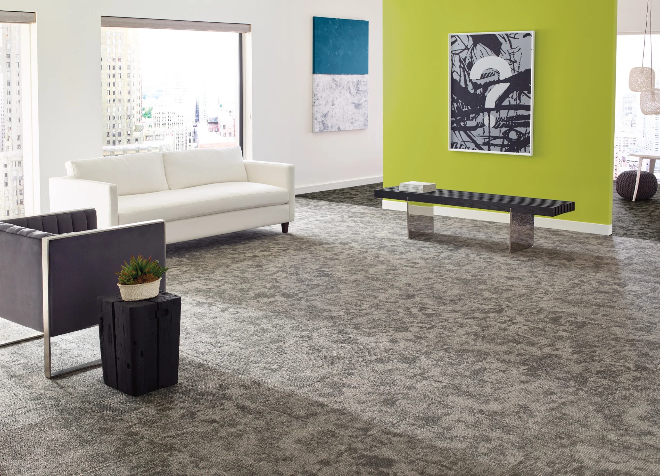 Modern office lounge with broadloom gray carpet, white sofa, and bold lime green accent wall