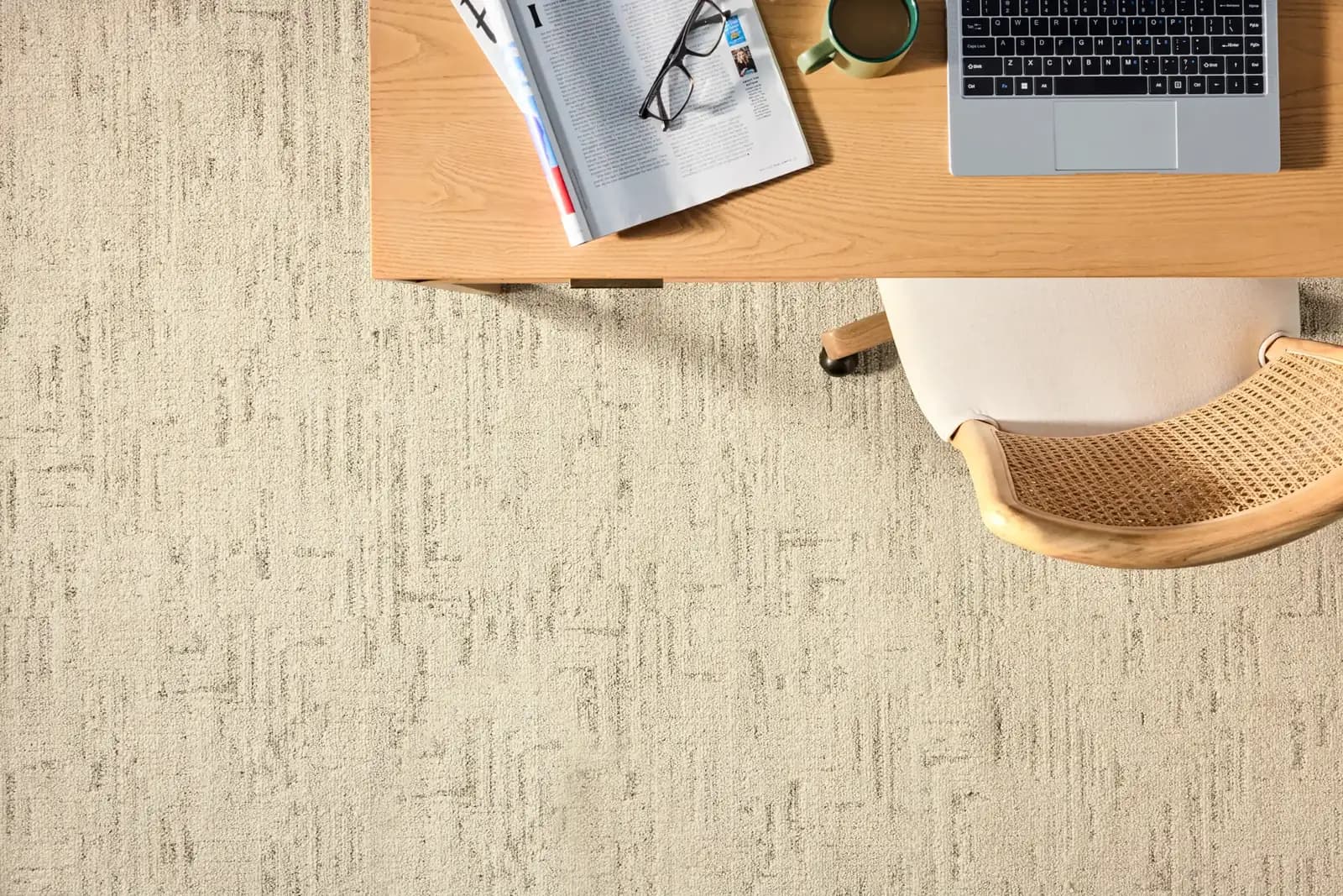 Overhead view of a home office desk on textured cream carpet