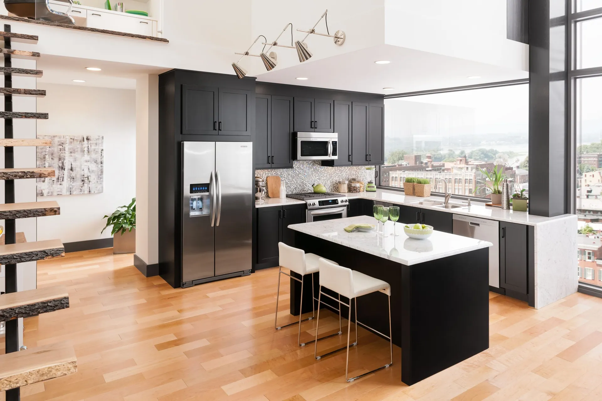 A kitchen with black cabinets, wood tones, and an island, from the Medallion cabinet line we carry