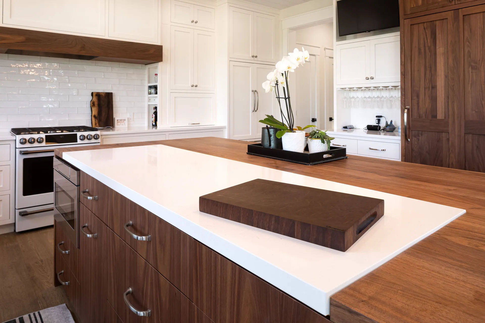 A wood island with a waterfall-edge quartz countertop, from the Cambria quartz line we carry