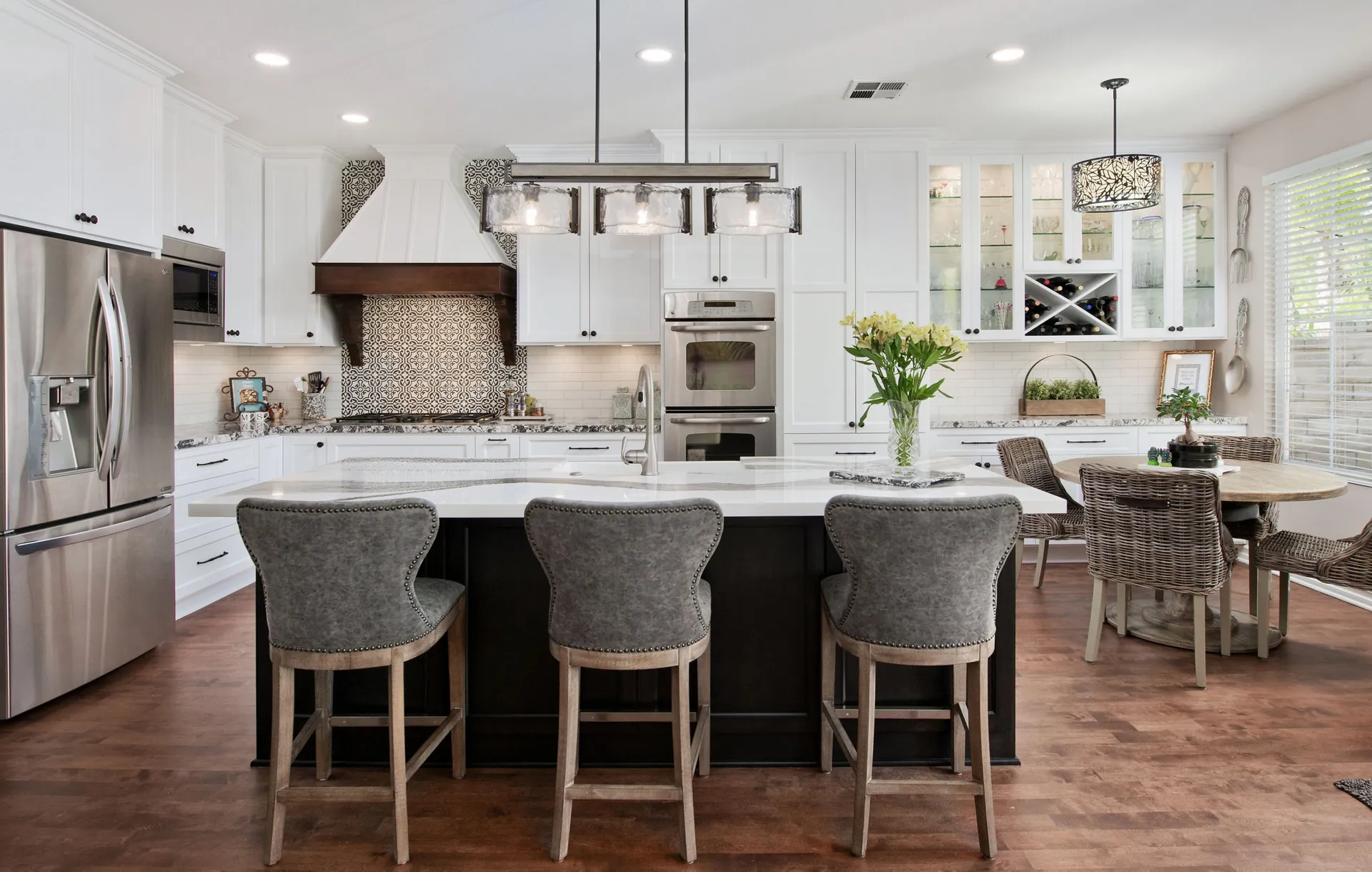 A kitchen with a dark island and a quartz countertop, from the Cambria quartz line we carry