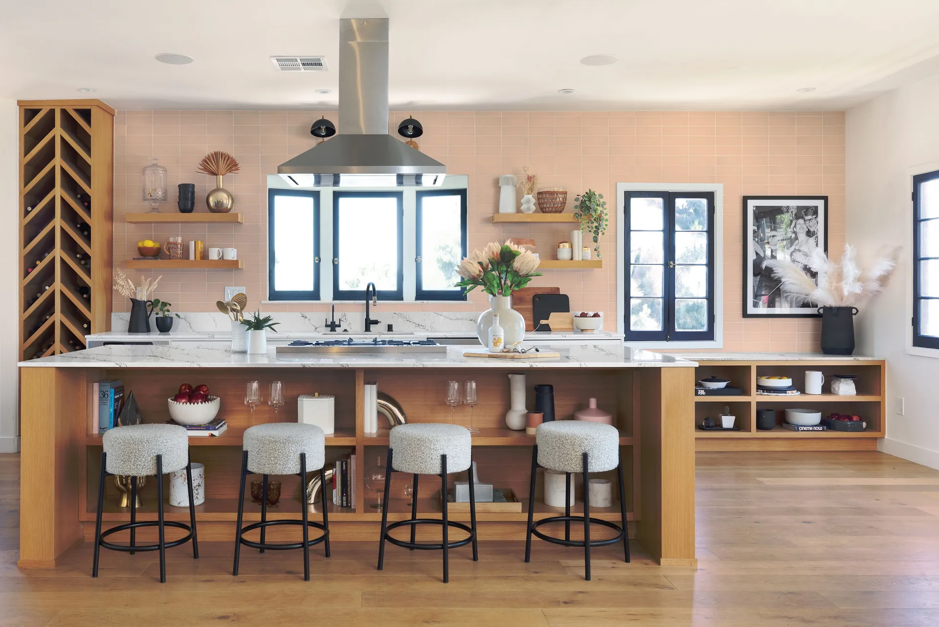 A warm kitchen with a quartz island and stools, from the Cambria quartz line we carry
