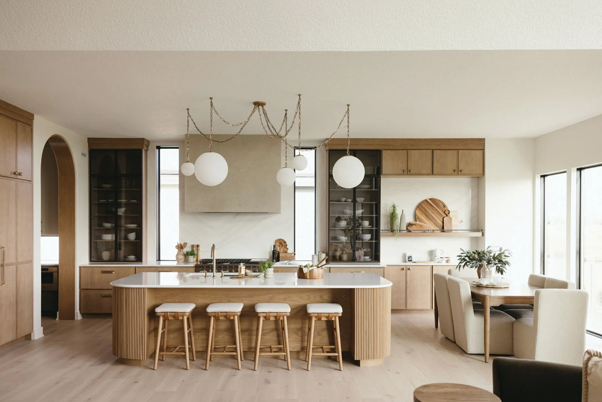 A wood and white kitchen with a quartz island, from the Cambria quartz line we carry