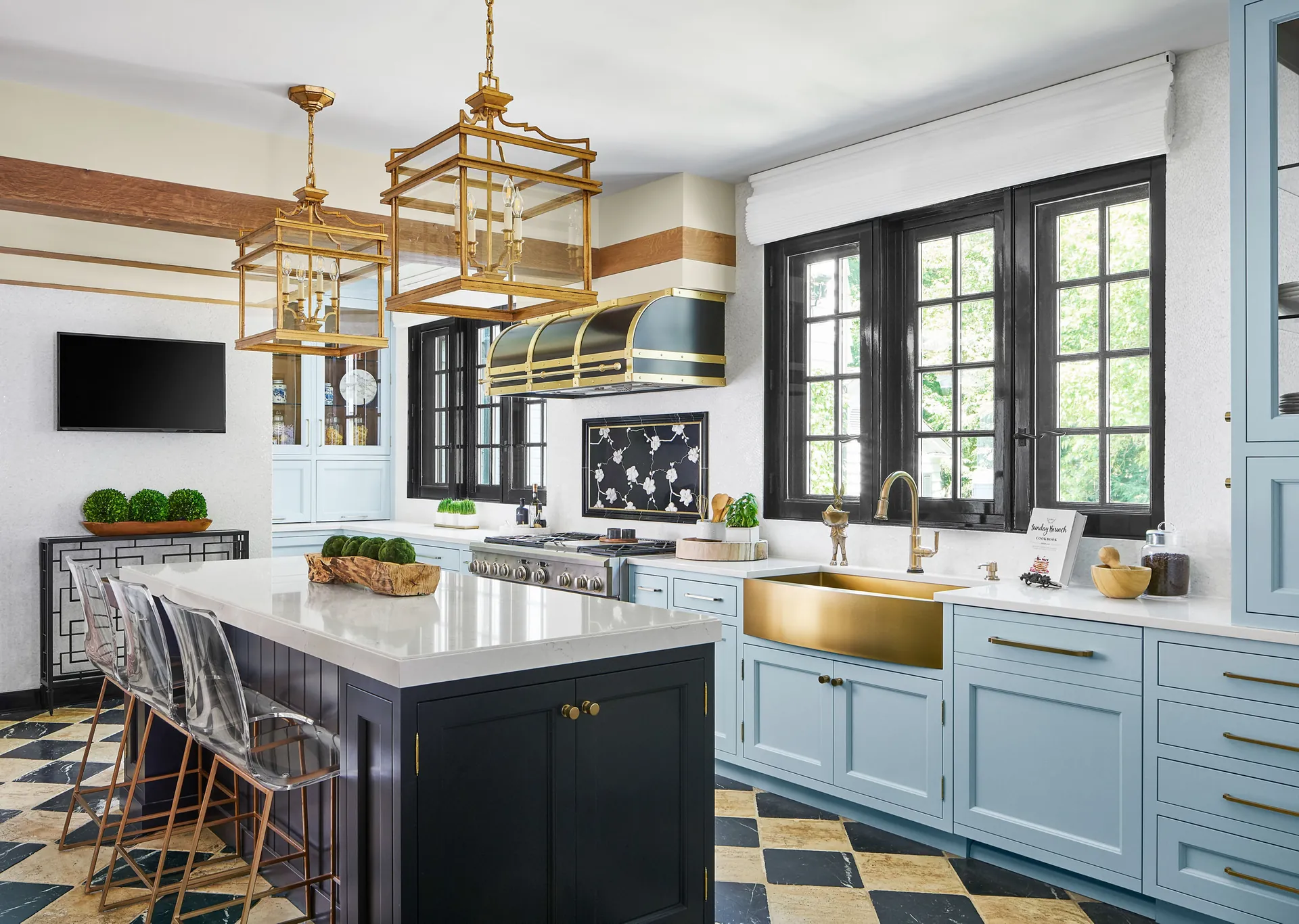 A dark and gold kitchen with a quartz island, from the Cambria quartz line we carry