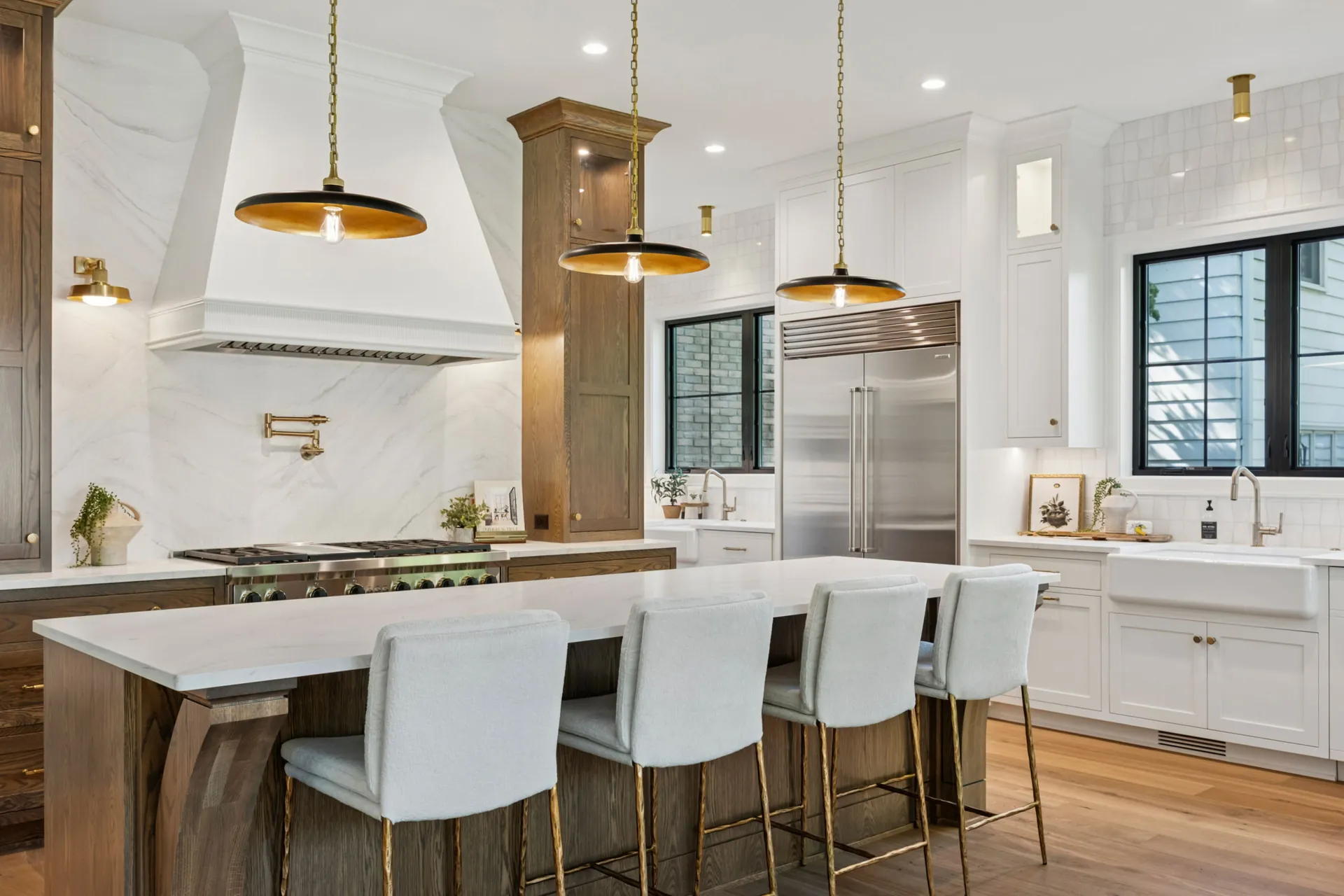 A white kitchen with a veined quartz island, from the Cambria quartz line we carry