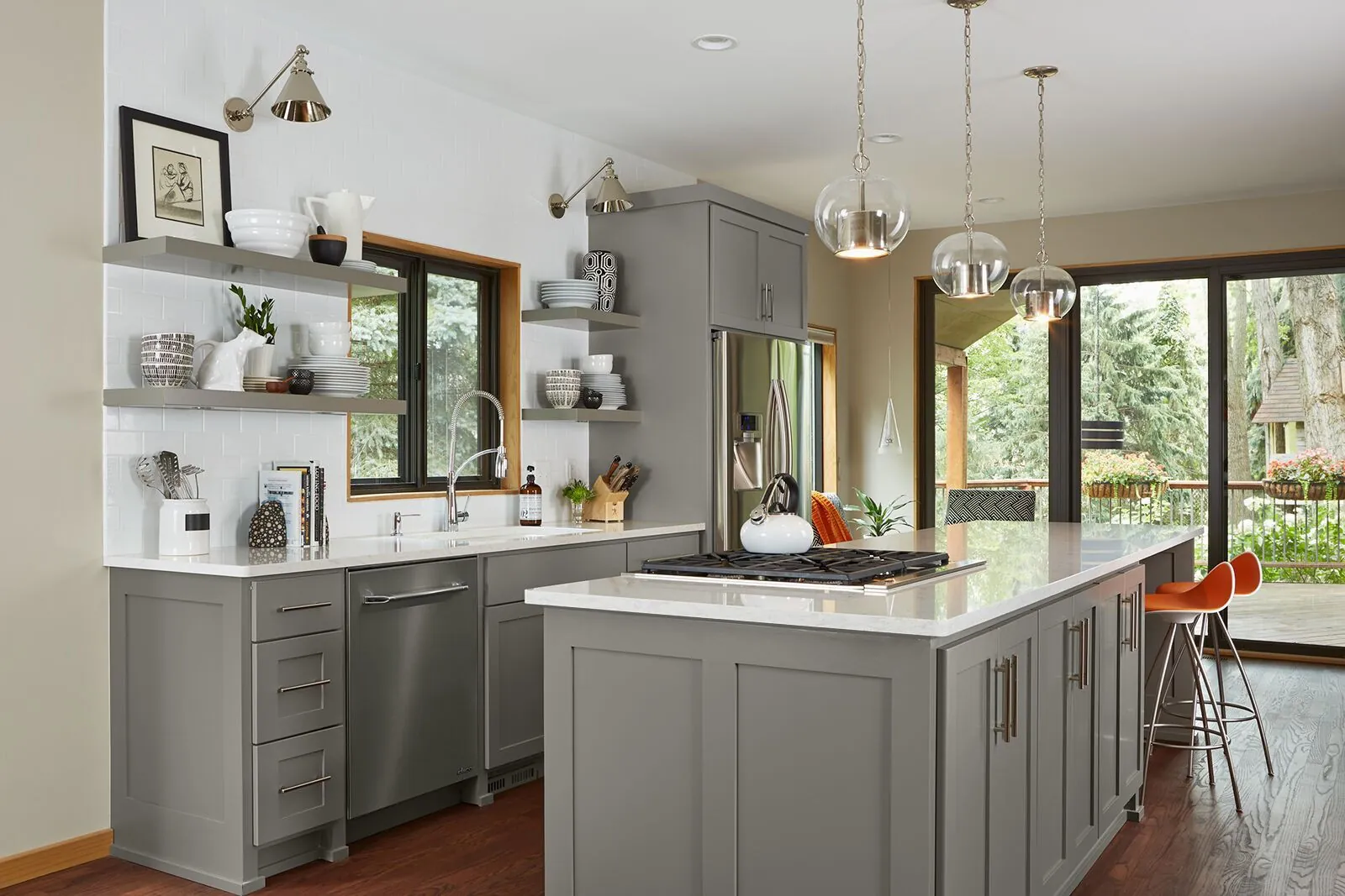 A grey kitchen with a quartz island tying the counters, cabinets, and floor together, from the Cambria quartz line we carry