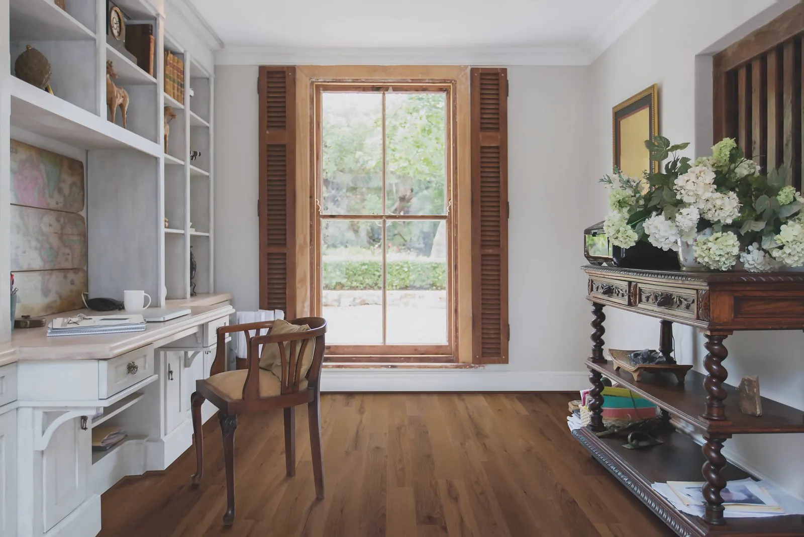 Warm medium brown hickory luxury vinyl plank flooring in a home office, from the COREtec line we carry