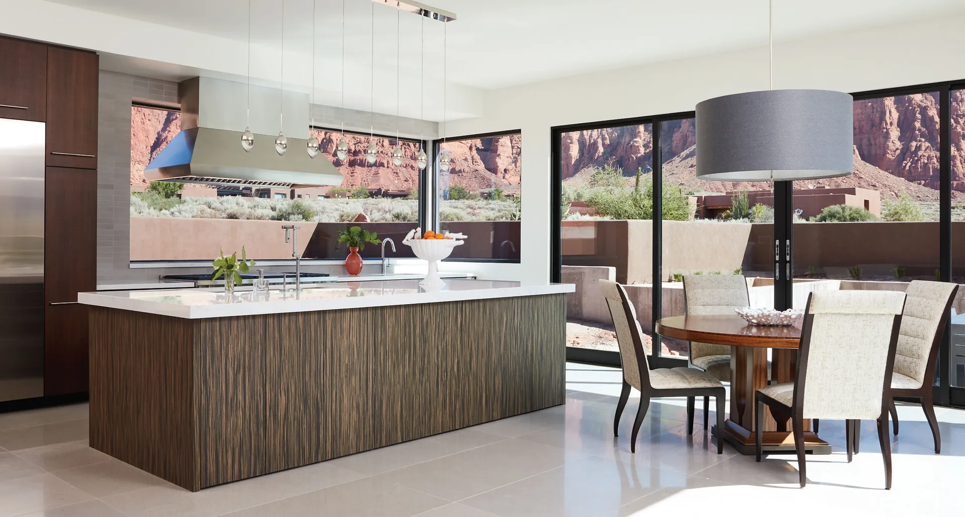 A modern kitchen with a wood island and a quartz countertop open to a view, from the Cambria quartz line we carry