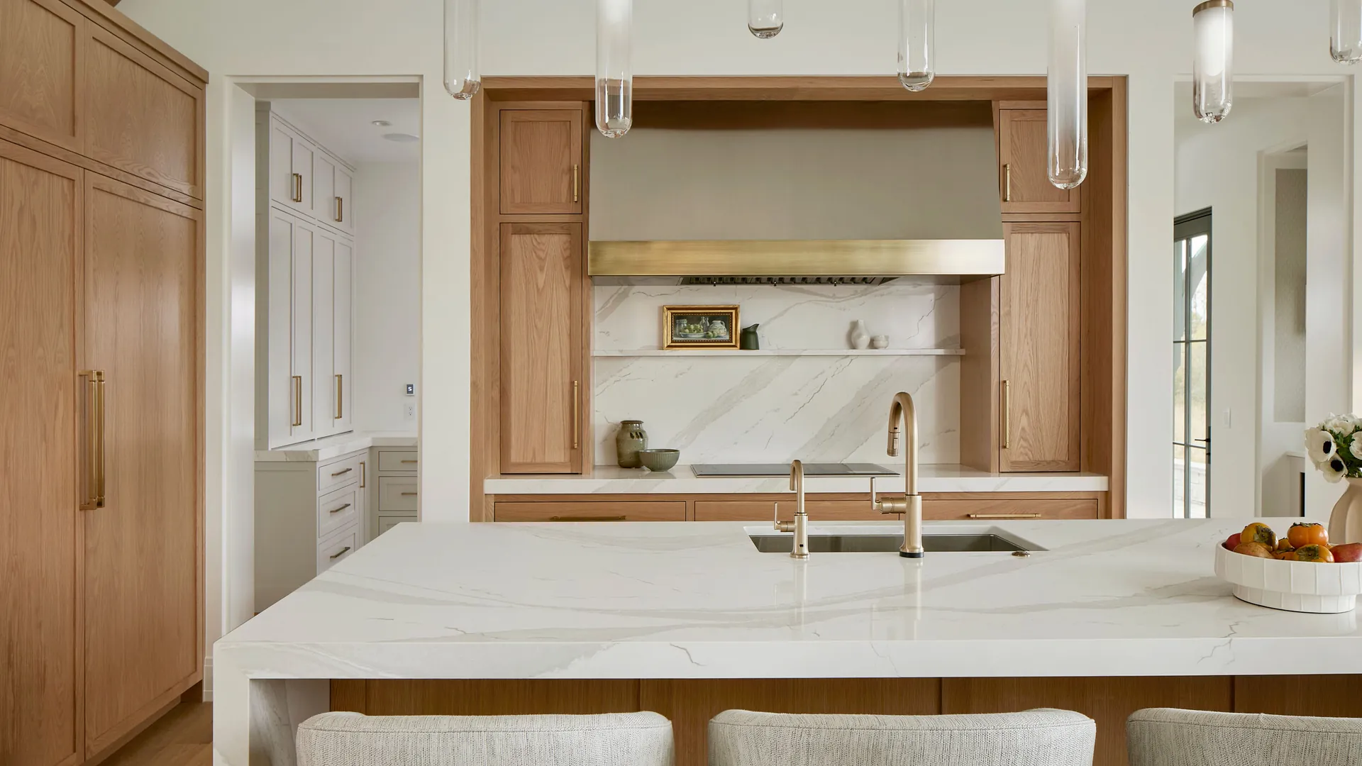 A modern kitchen with a wood island and a marble-look countertop