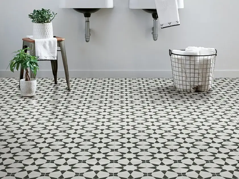 Patterned black-and-white encaustic porcelain floor tile in a modern bathroom with vessel sinks