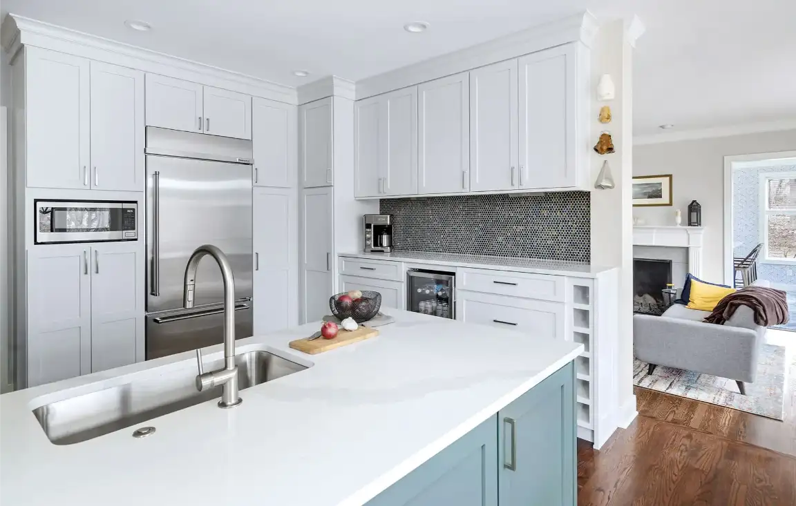 Bright kitchen with white shaker cabinets and a soft teal island, an example of the custom cabinetry Blackburn's Interiors offers Haines City, FL homeowners, family-owned since 1962