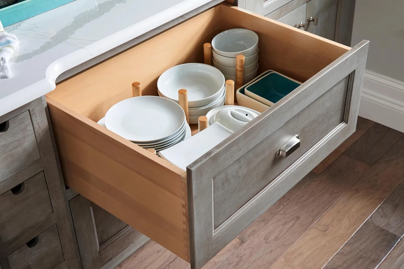A deep Medallion drawer with movable wooden pegs holding plates and bowls in place