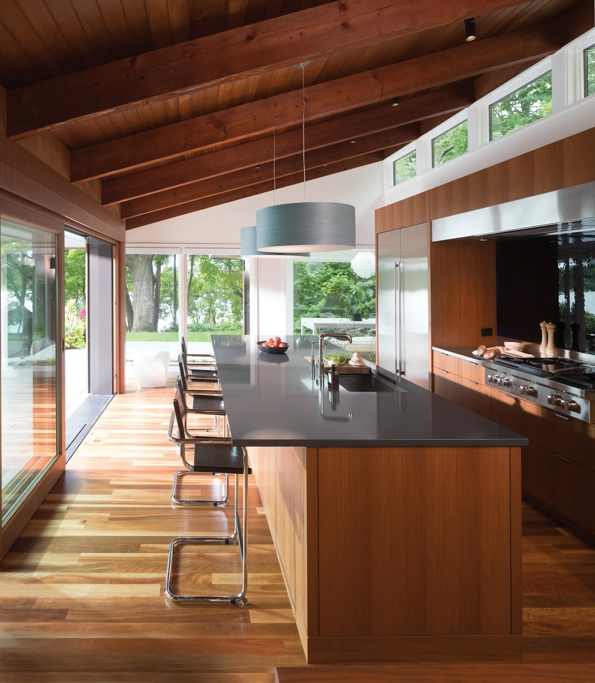 Cambria Ella Matte quartz kitchen with a dark island under a vaulted wood ceiling, from the Cambria line we carry
