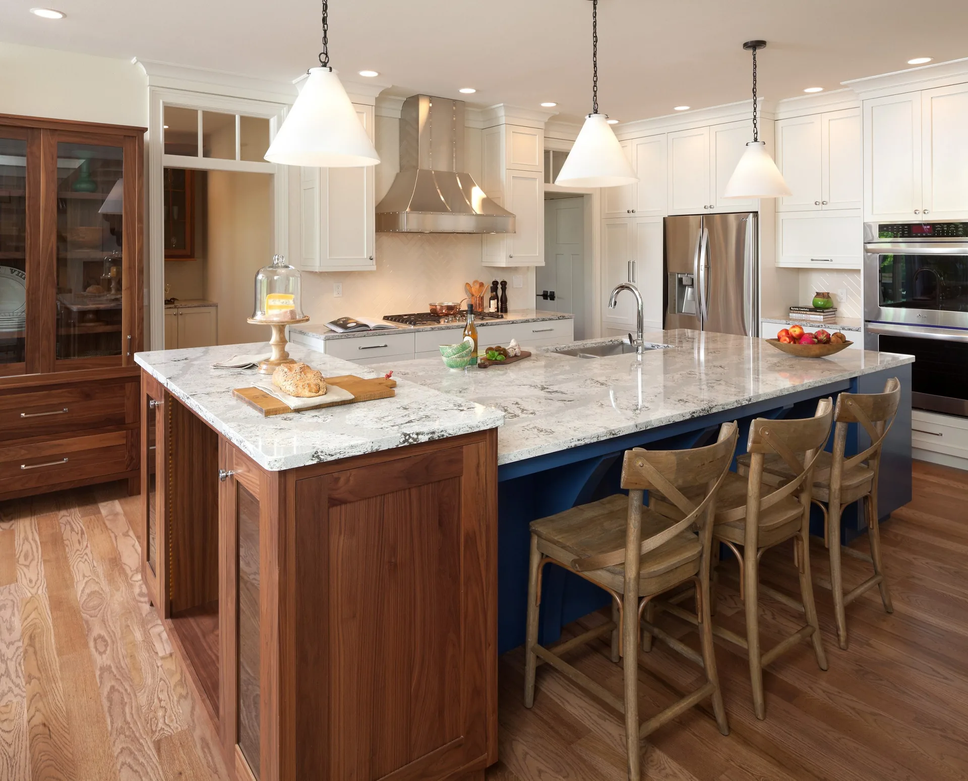 Cambria Summerhill quartz atop a blue island in a wood kitchen, from the Cambria line we carry