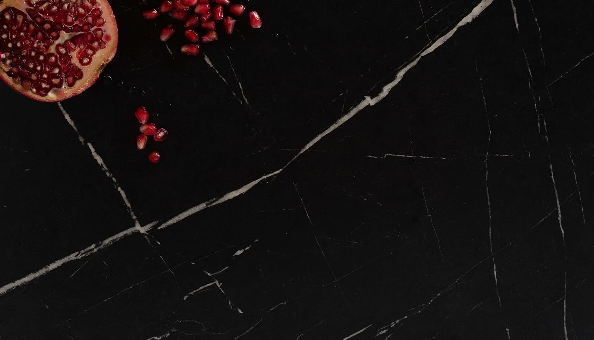 Wilsonart marble-look countertop and backsplash in a dark modern kitchen, from the Wilsonart line we carry