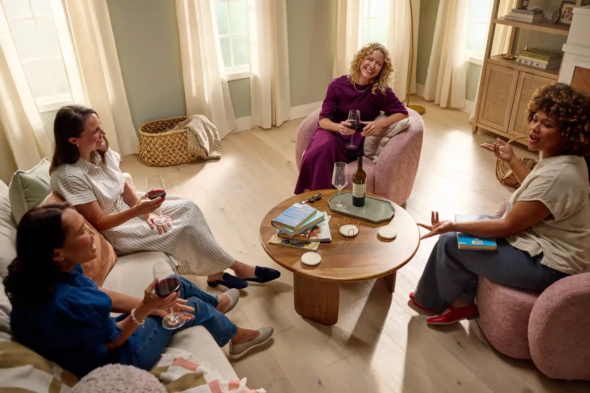 Three friends chatting on soft carpet in a bright living room — flooring FAQ for Winter Haven, FL