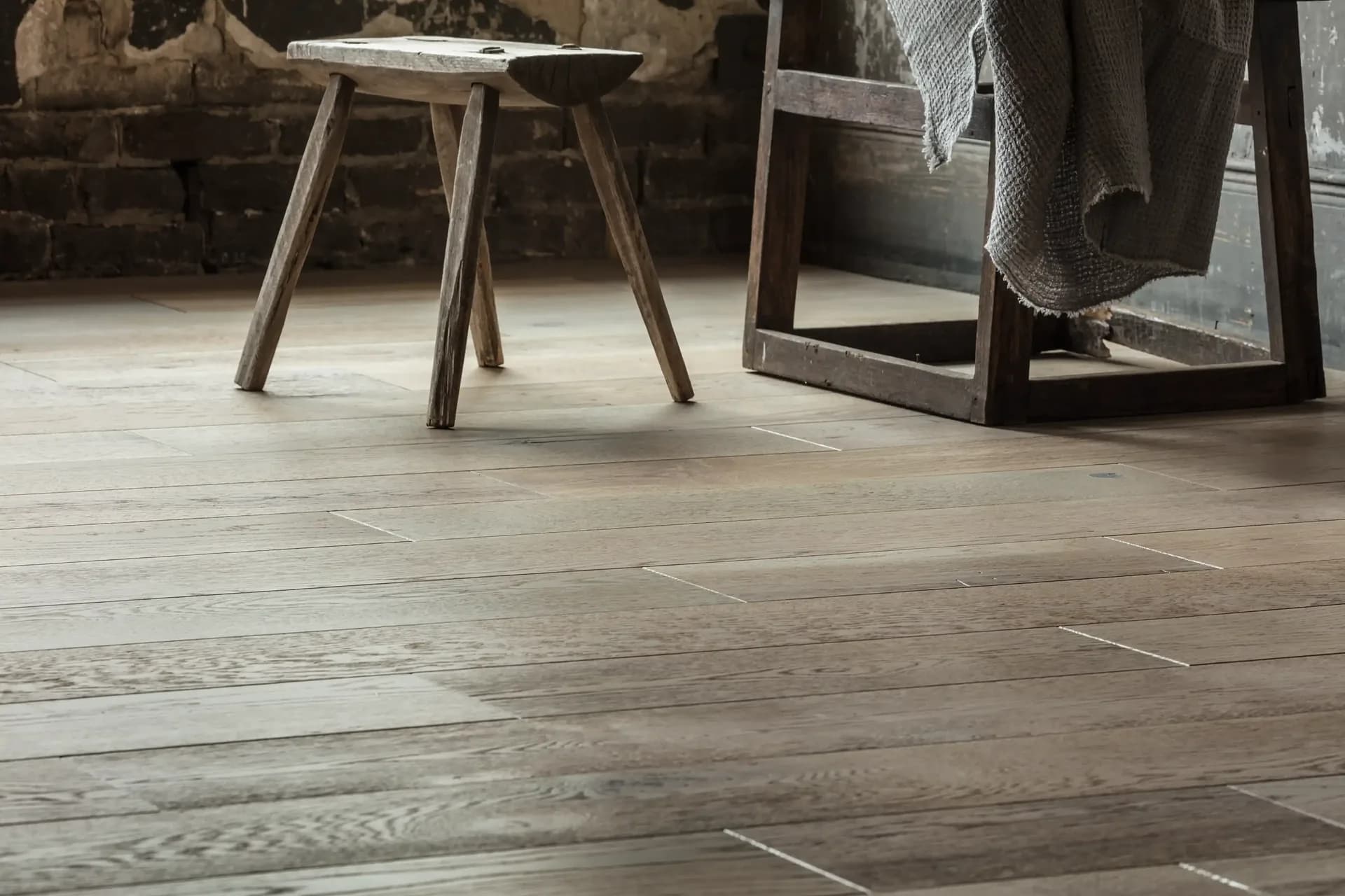 Anderson Tuftex Metallics hardwood in Pewter, wide gray oak planks in a rustic room — Winter Haven, FL dealer