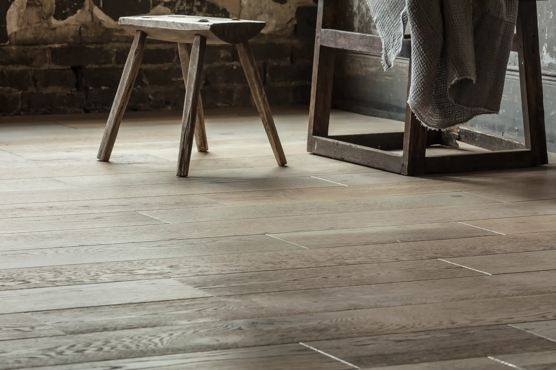 Anderson Tuftex Metallics hardwood in Pewter under a rustic bench. Carried by Blackburn's Interiors, Winter Haven, FL