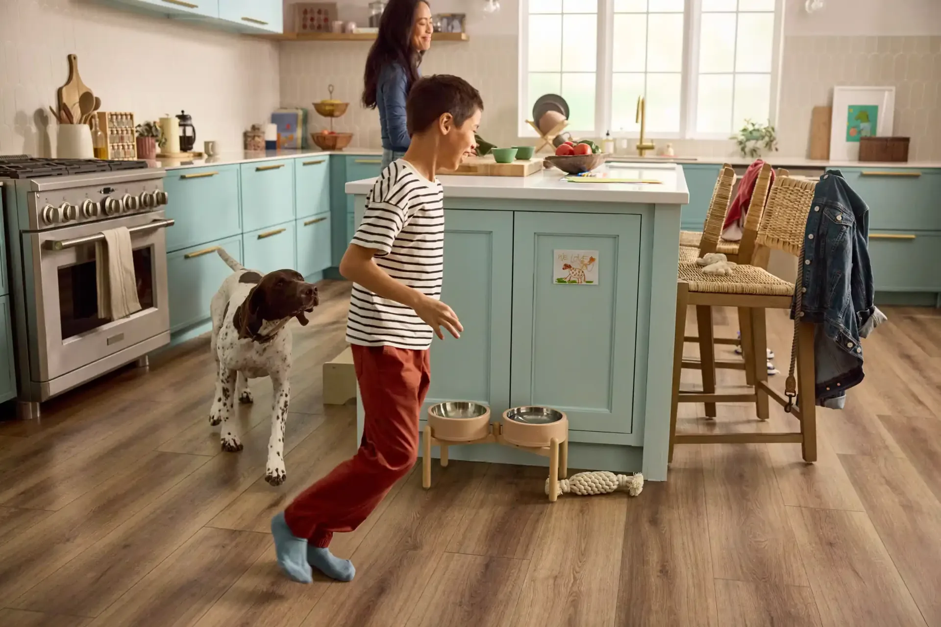 Boy dancing with his dog on waterproof LVP in a kitchen — flooring for Davenport, FL homes