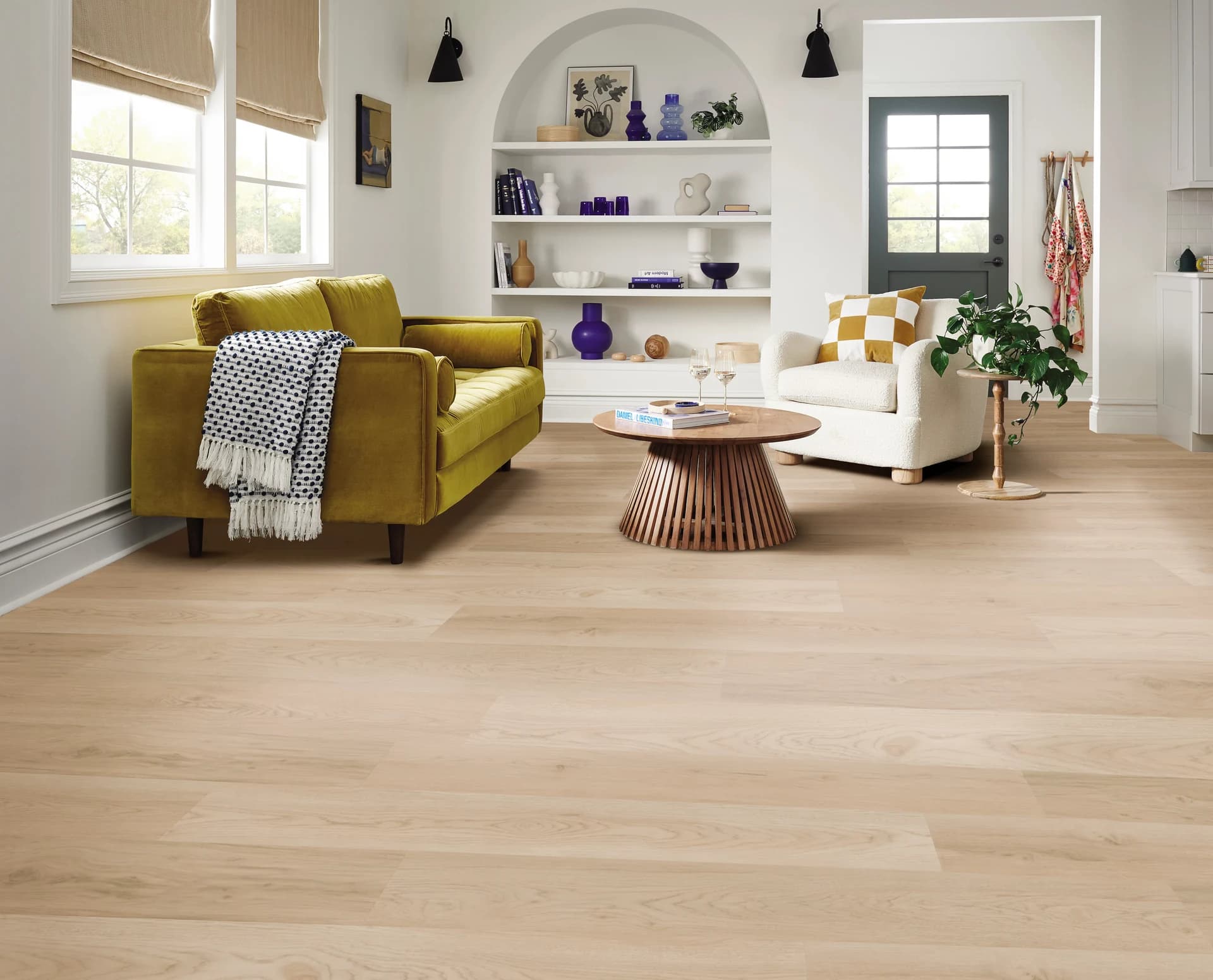 Shaw Ignite luxury vinyl plank in Ashen Sand in a white living room with a chartreuse sofa. Luxury vinyl plank for Bartow, FL homes