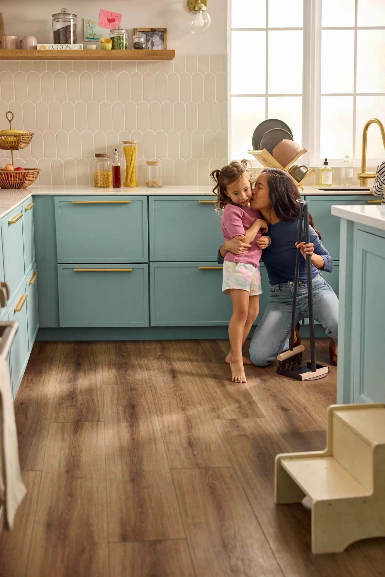 Shaw Floors Pet Perfect Briard luxury vinyl plank in Coffee Oak in a teal kitchen, a wood look Blackburn's carries for Lake Wales, FL homes.