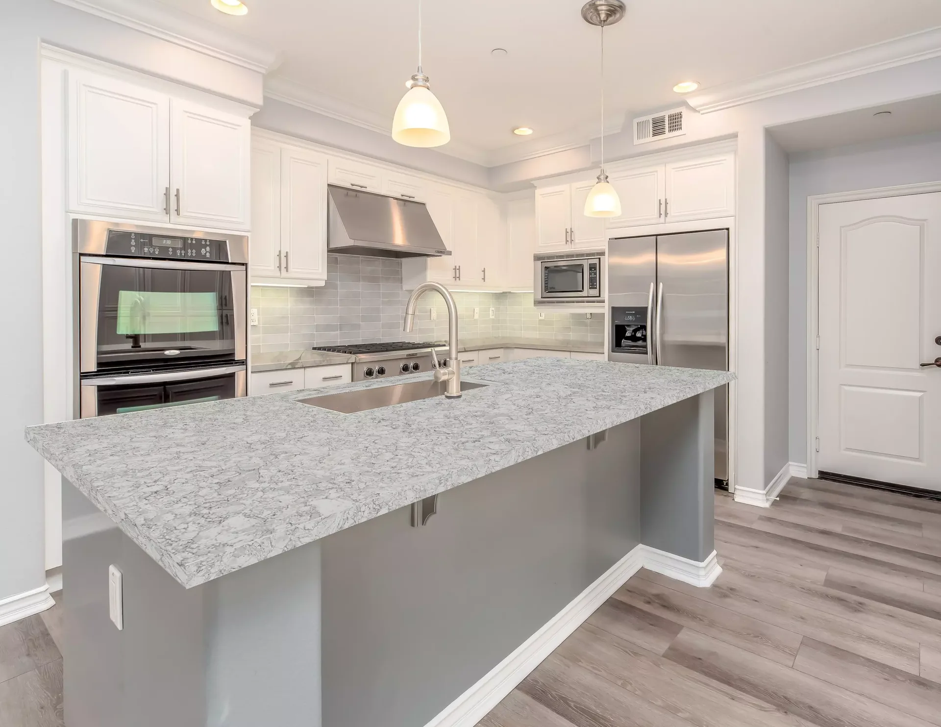 Quantum Quartz Altair Select countertops in a white kitchen, from the Quantum Quartz line we carry