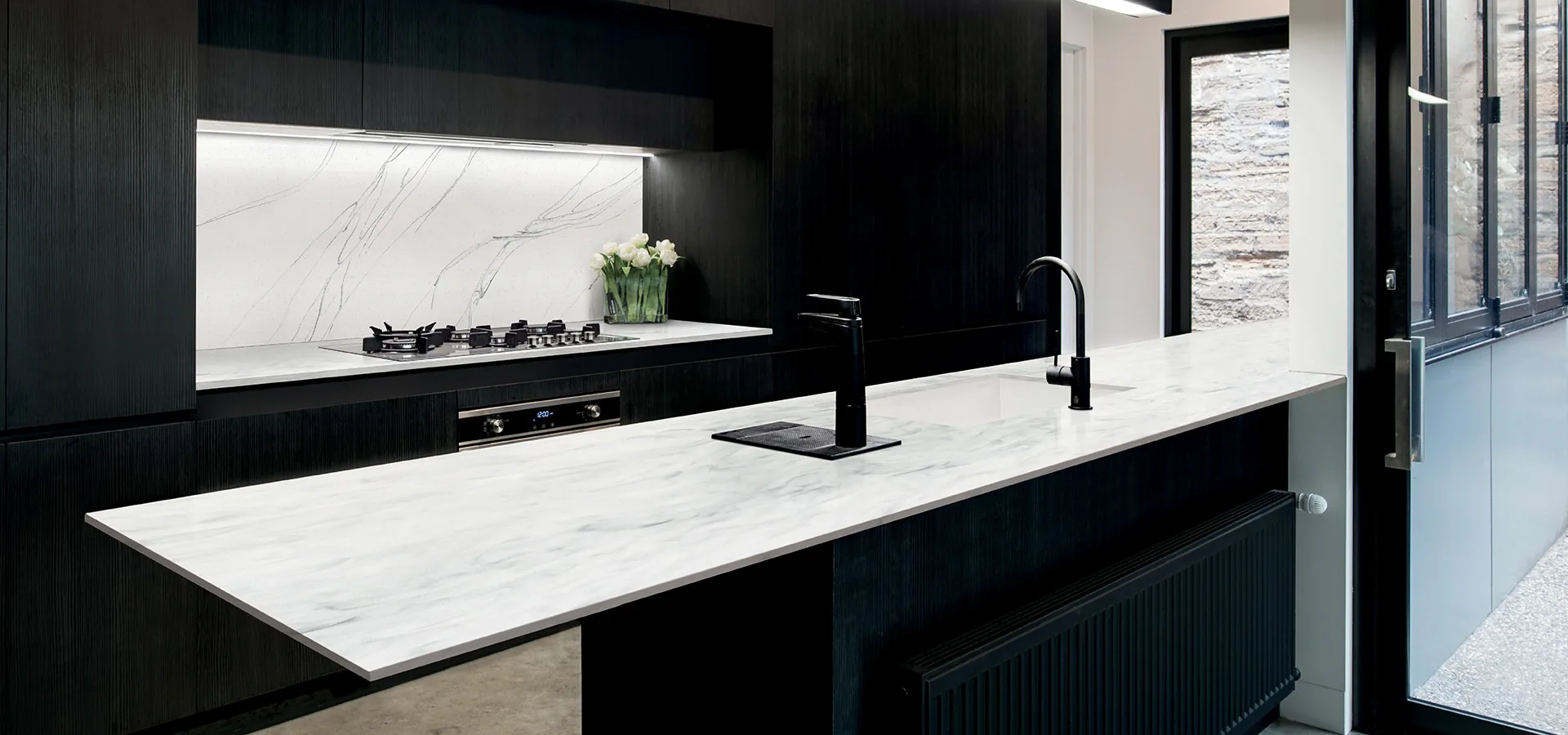 Wilsonart countertops in a black and white modern kitchen, from the Wilsonart line we carry