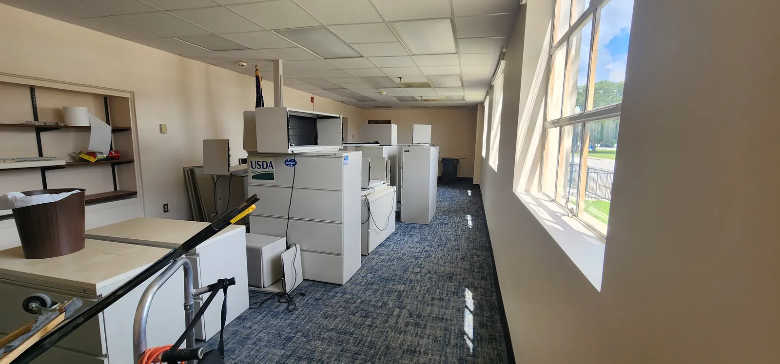 Office at the Winter Haven Federal Building with new carpet tile down and cabinets pushed aside during the phased install