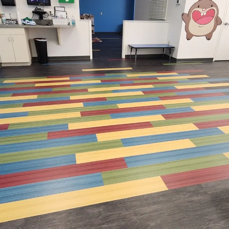 Overhead angle of the multicolored accent rectangle in the kids gathering area with the snack counter and Heartland mascot in the background