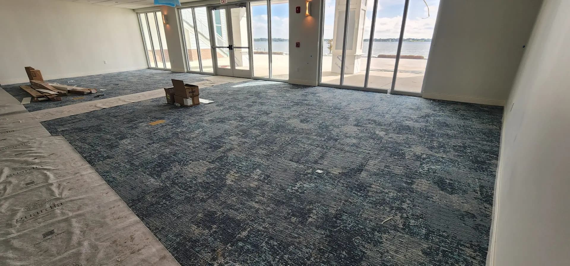 Blue patterned carpet tile installed in a side gathering room facing the lake at the Lake Ariana Civic Center, Auburndale, FL