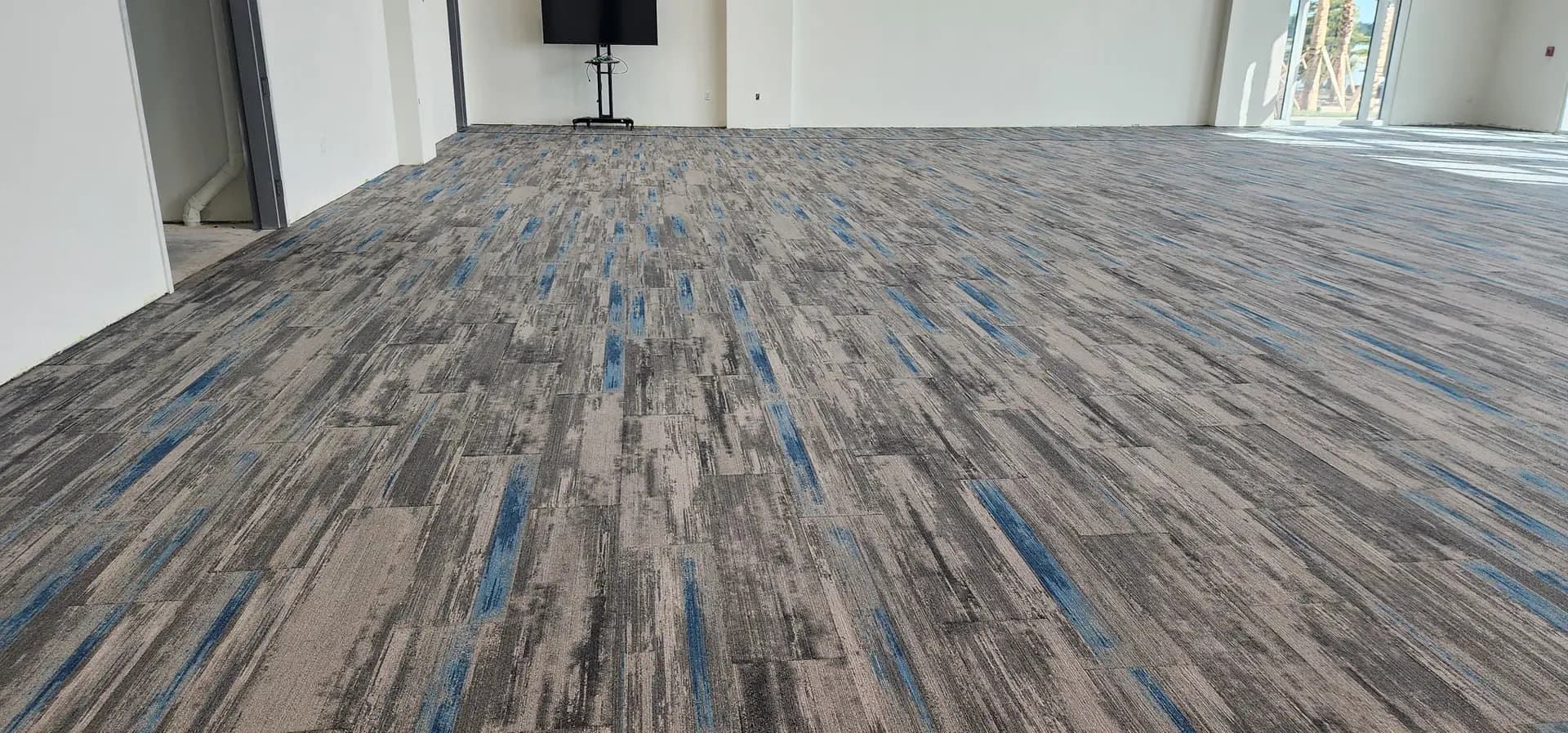 Detail of the gray and blue patterned luxury vinyl plank running through the entryway and hallway of the Lake Ariana Civic Center