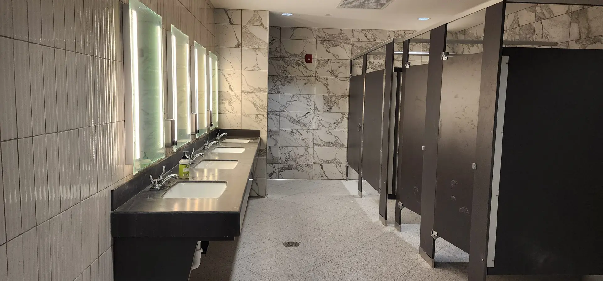 Calacatta-look porcelain wall tile and terrazzo-look floor tile in the Lake Ariana Civic Center restroom