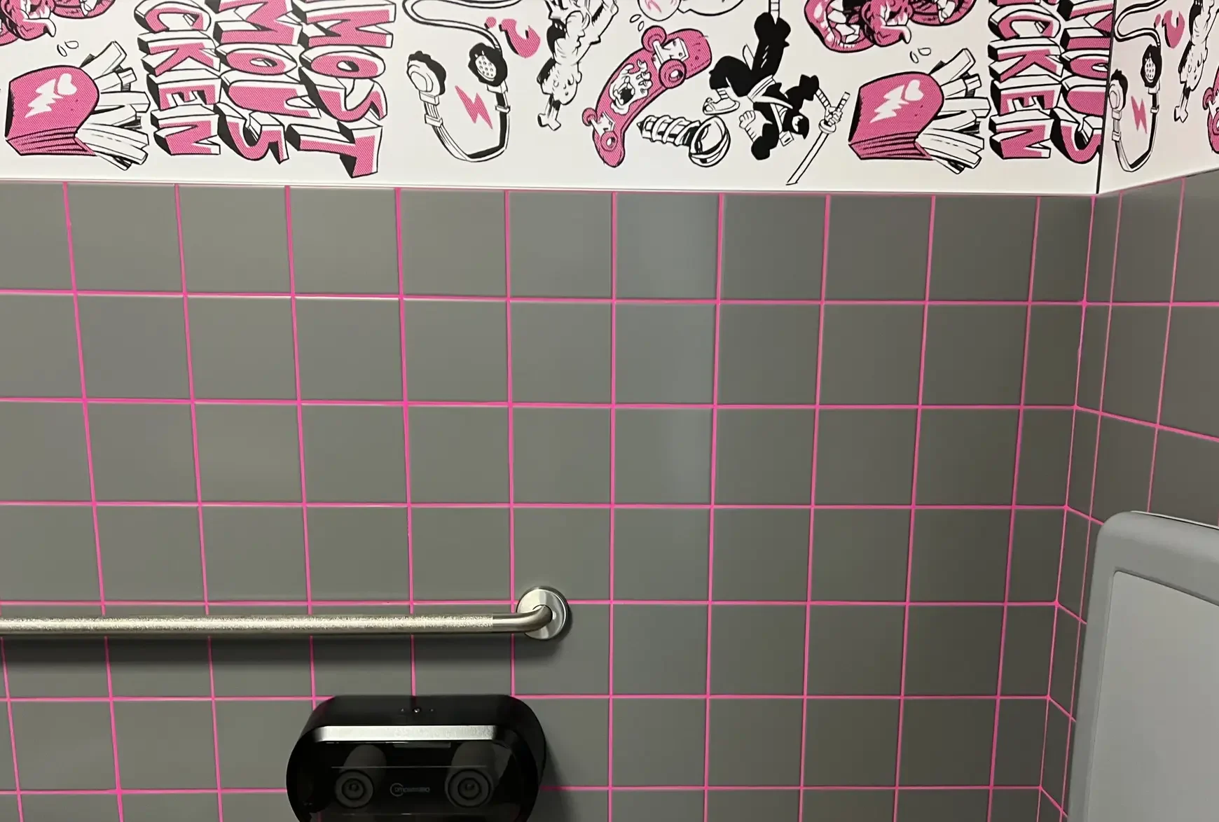 Gray square wall tile set with custom hot pink grout in the LoveBird Chicken restroom in Winter Haven, FL