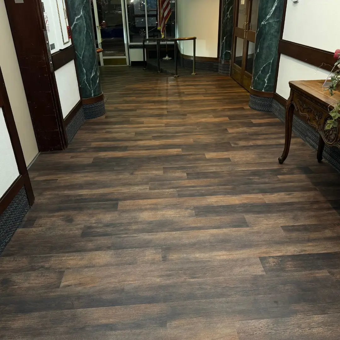 Luxury vinyl plank runs through the historic Munn Park lobby hallway with the existing green marble columns and trim retained