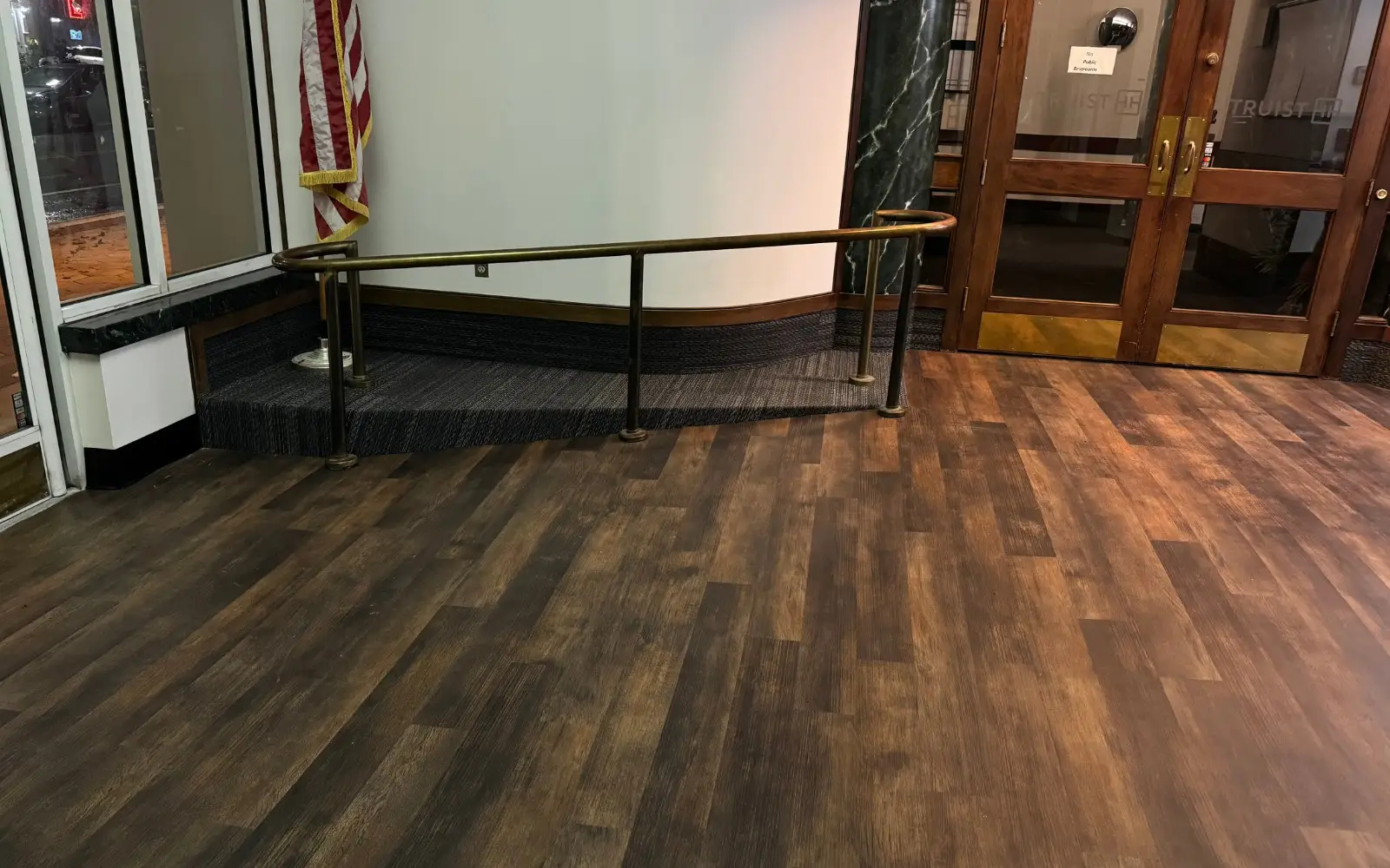 Dark wood-look luxury vinyl plank lobby floor in front of the Truist Bank entry doors at the historic Munn Park Building in Lakeland, FL