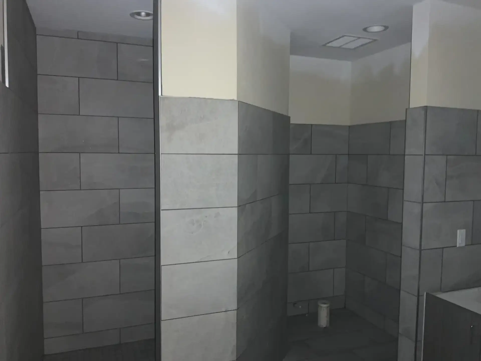 Shower and changing area at Winter Haven Fire Station #4 with full-height gray porcelain tile on every wall