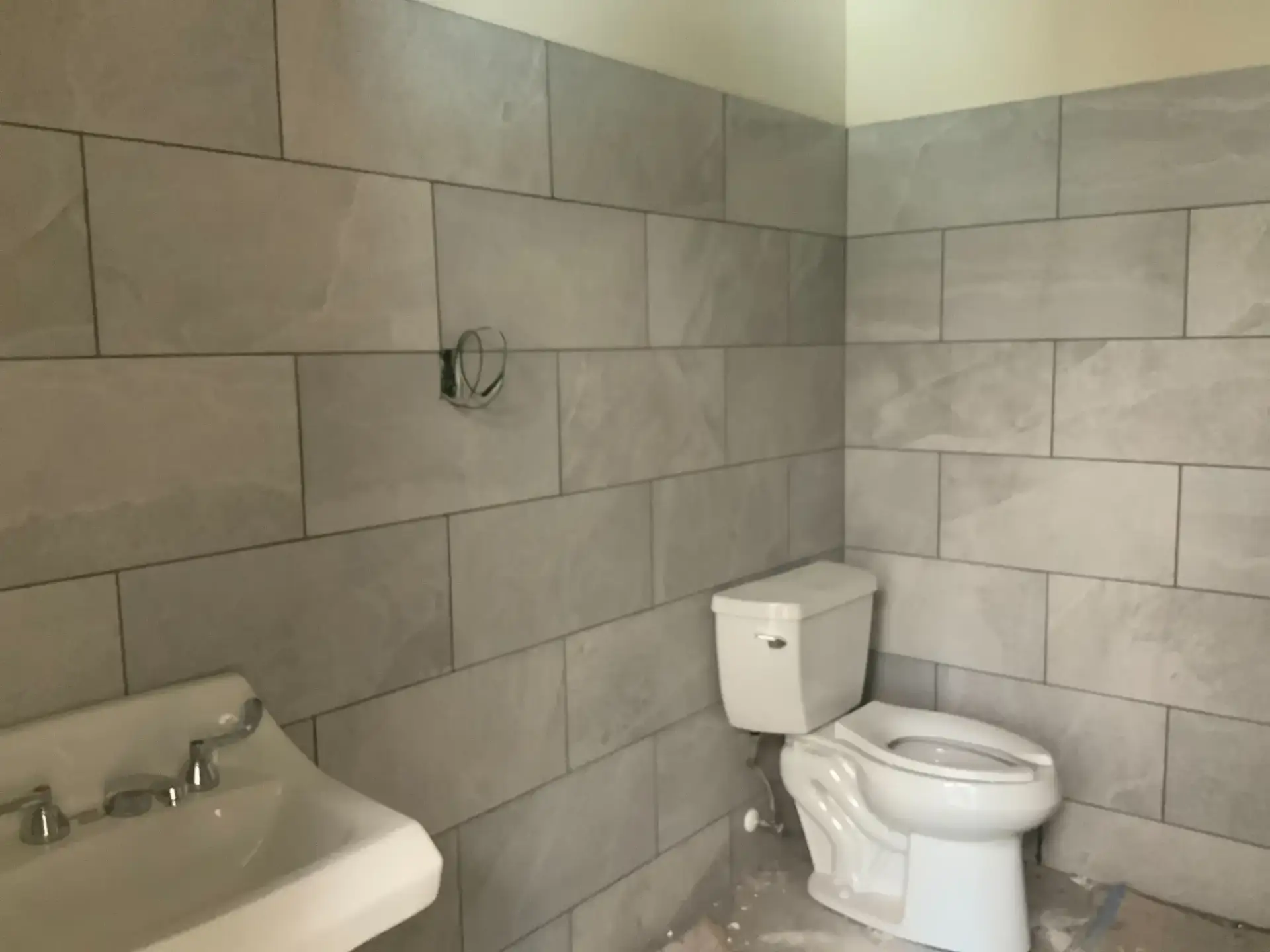 Large-format gray porcelain wall tile in a restroom at Winter Haven Fire Station #4, installed by Blackburn's Interiors, Winter Haven, FL