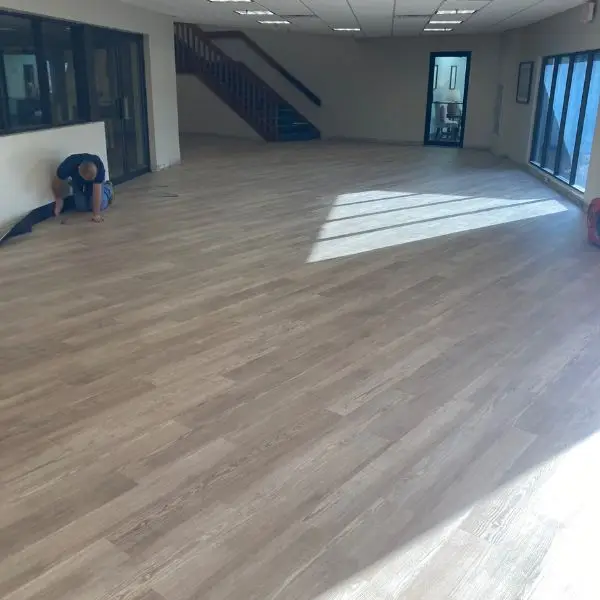Wide view of the finished light oak Shaw Floors LVP installation through the Winter Haven Nazarene foyer and stairwell